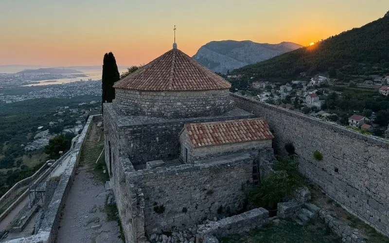 Sunset view over the historic stone Klis Fortress overlooking Split.