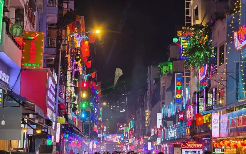 Bright neon signs and crowds along Bùi Viện Street in Ho Chi Minh City.