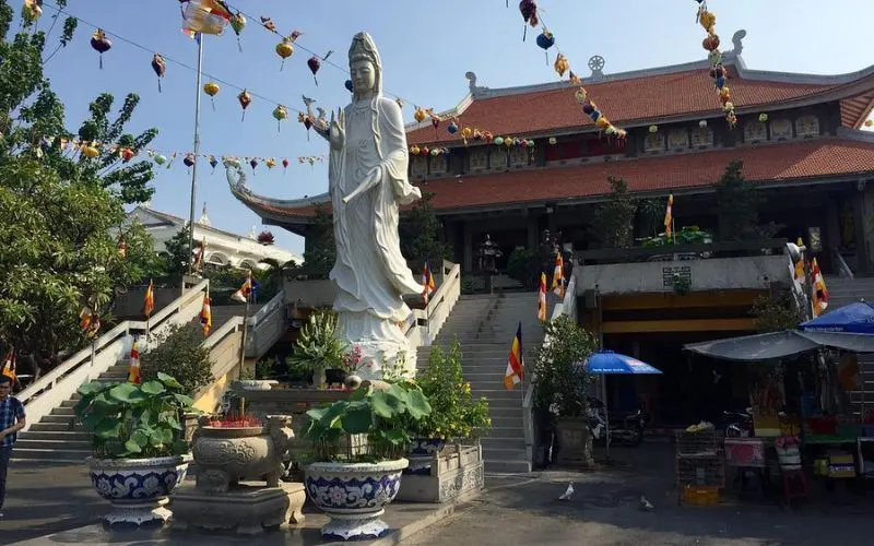 Large white Buddha statue in front of Vĩnh Nghiêm Pagoda in Ho Chi Minh City.