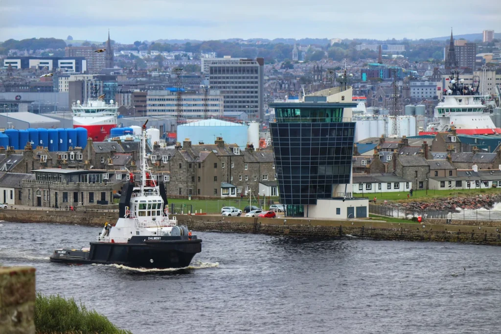 The Dalmeny tugboat navigates past the modern Marine Operations Centre tower at the port entrance