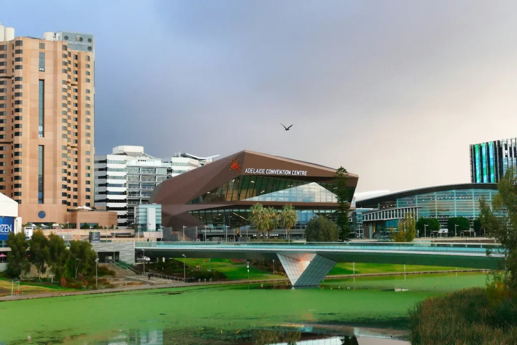 Adelaide Convention Centre building situated across the River Torrens under a dramatic sky