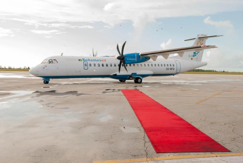 Bahamasair ATR 72-600 turboprop passenger airplane parked on the tarmac behind a red carpet