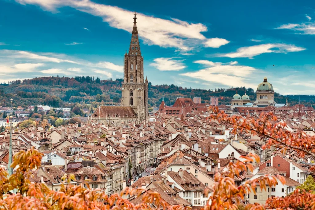 The historic Bern Minster tower rising above the dense red rooftops of Old Town Bern, Switzerland