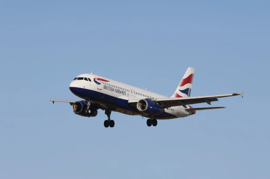 British Airways Airbus A320 narrowbody airliner flying with its landing gear fully extended