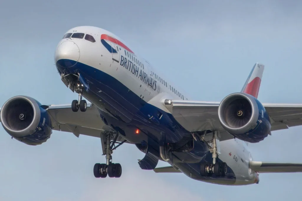 A close-up, low-angle view of a British Airways Boeing 787-9 Dreamliner passenger airplane descending