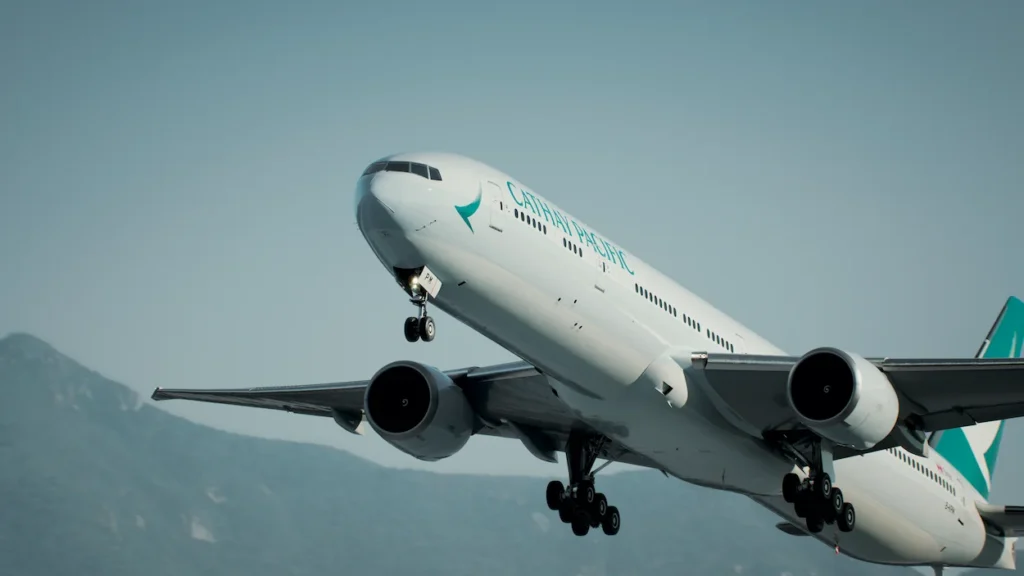 Cathay Pacific Boeing 777-300ER passenger airplane soaring into the sky immediately after takeoff