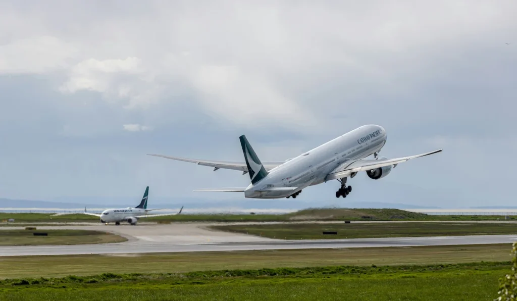 Cathay Pacific Boeing 777 climbing into the sky during takeoff from an airport runway