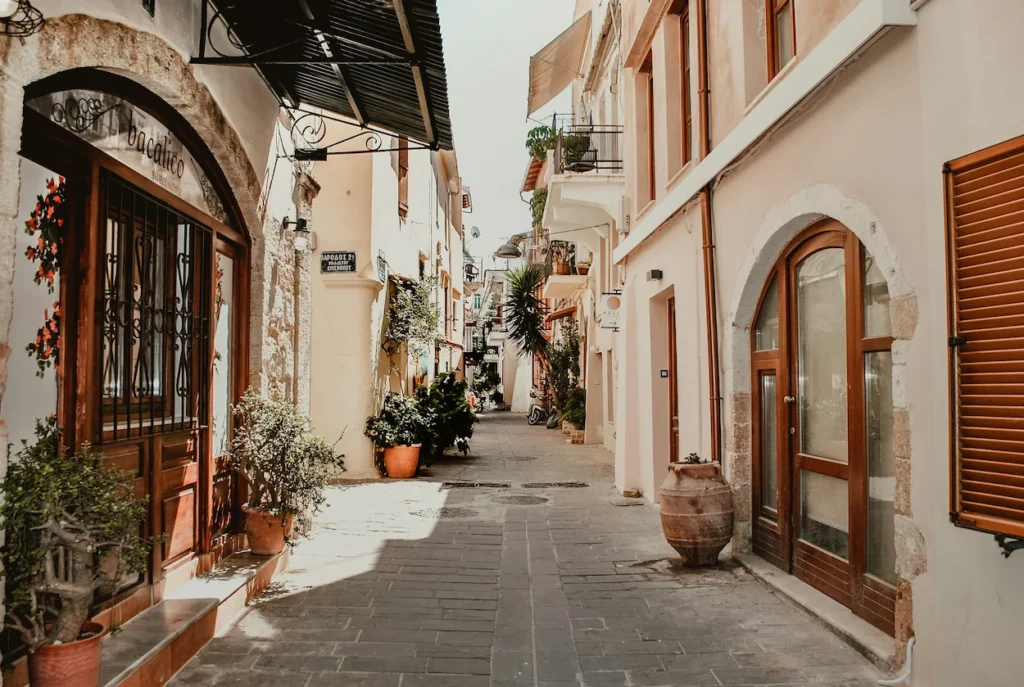 A narrow stone alley lined with historic buildings and storefronts in Chania, Crete