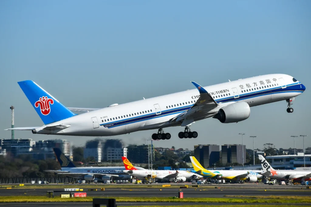China Southern Airlines Airbus A350-900 passenger airplane climbing into a clear blue sky during takeoff