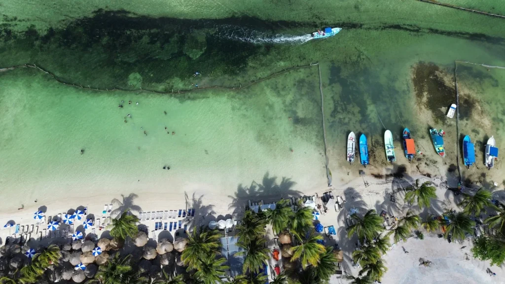 Aerial drone view of small fishing boats anchored along the turquoise shore of Mahahual Beach in Costa Maya