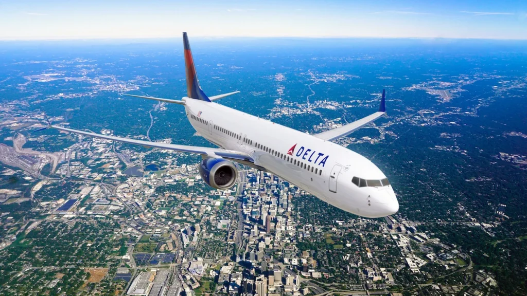Delta Air Lines Boeing 737 MAX passenger airplane flying in mid-air high above a sprawling city