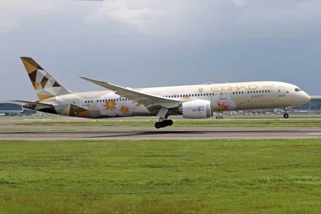 Etihad Airways Boeing 787-9 Dreamliner with a pink cherry blossom livery landing on a runway
