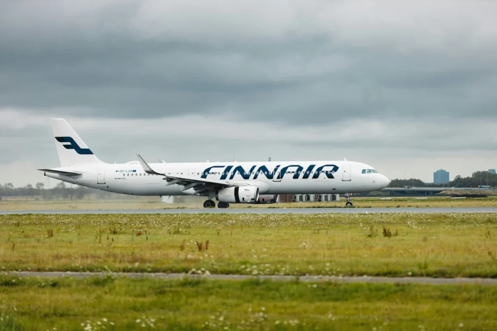 A white Finnair Airbus A321 passenger plane taxiing along a runway
