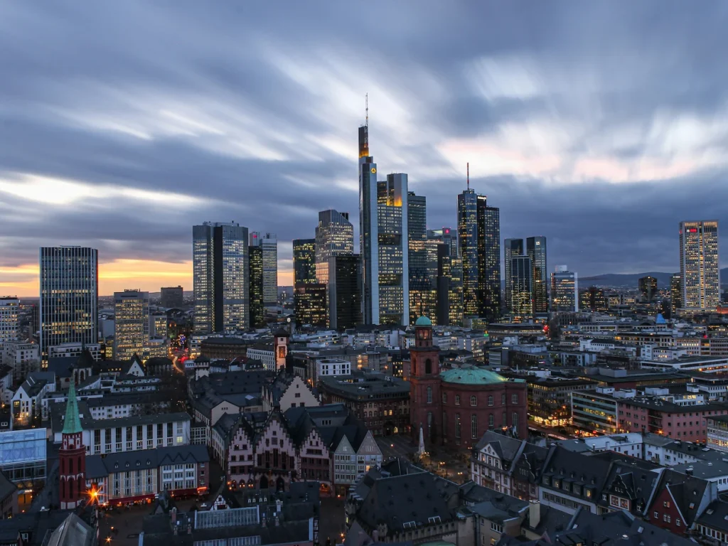 The modern Frankfurt skyline rising above the historic Römerberg and St. Paul's Church at dusk