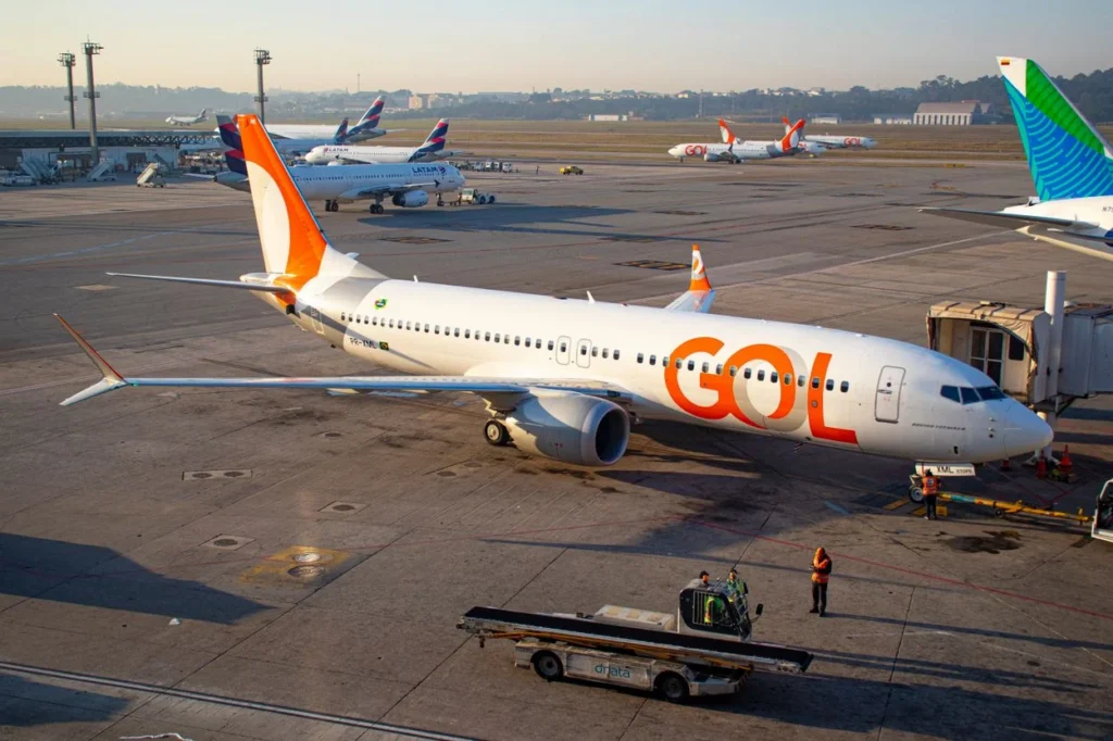 Overhead view of a white and orange GOL Linhas Aéreas Boeing 737 MAX 8 passenger airplane