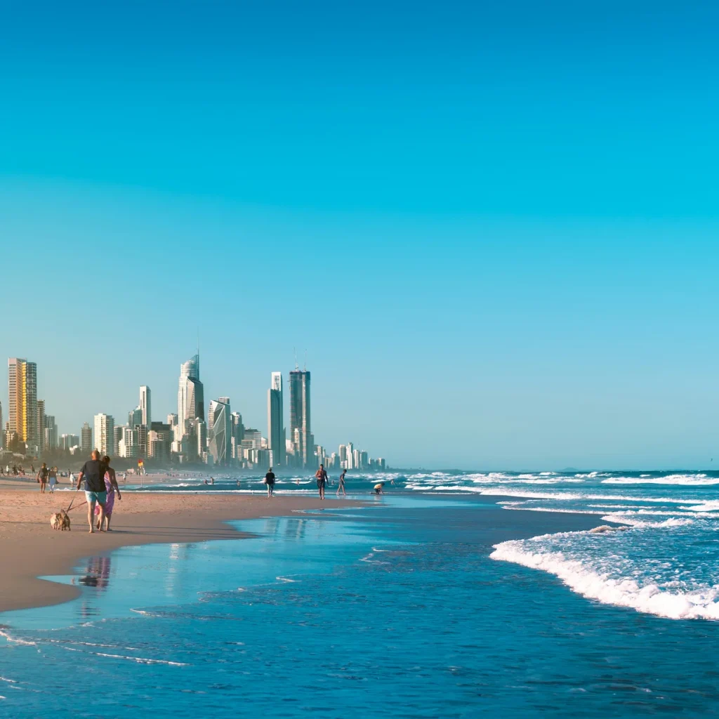 Surfers Paradise beach waves rolling onto the sand with Gold Coast skyscrapers lining the background