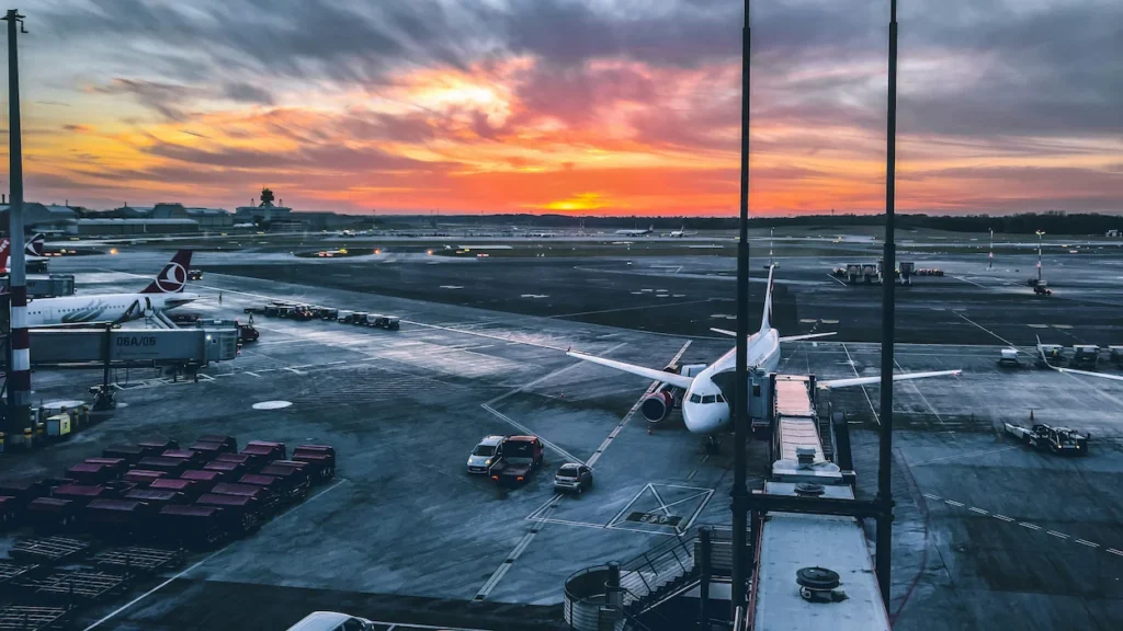 Eurowings and Turkish Airlines airplanes parked at terminal gates during a vibrant sunset