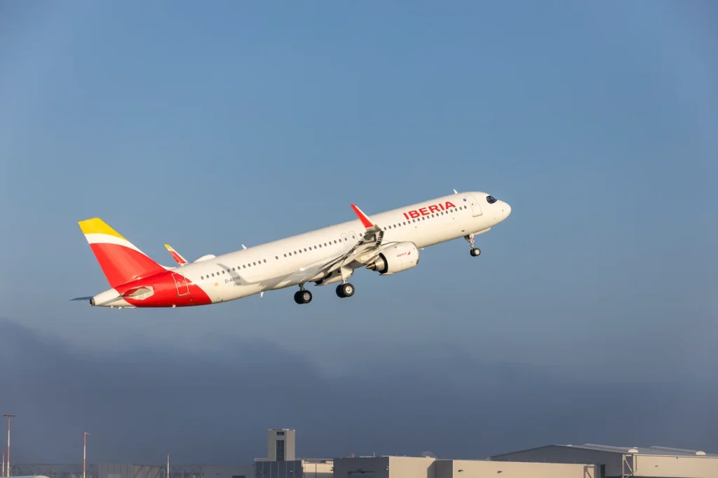 An Iberia Airbus A321XLR commercial passenger jet climbing rapidly into a clear blue sky