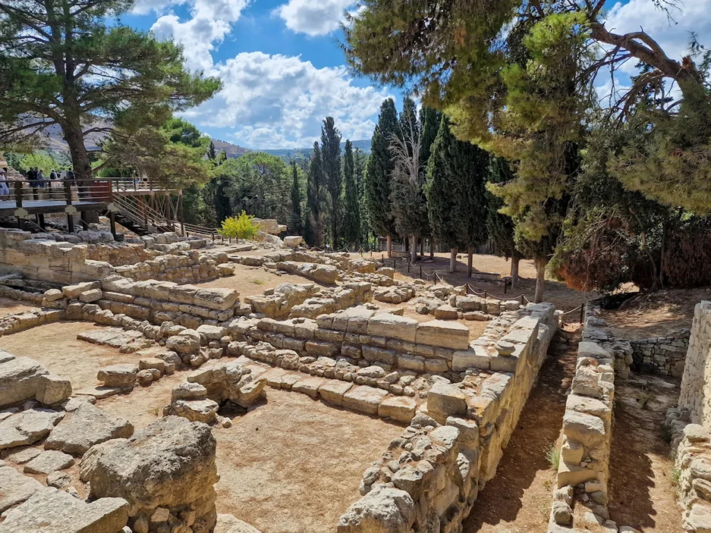 The stone foundations of Knossos Palace in Crete surrounded by pine trees