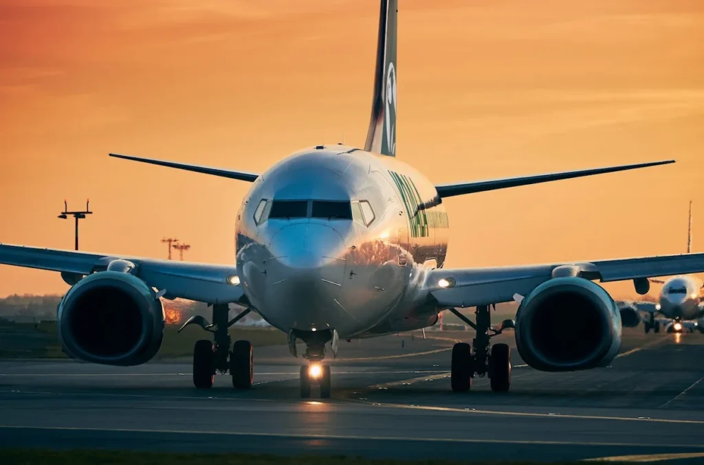 Front view of a Koala Airlines Boeing 737 airplane taxiing on the runway tarmac during sunset