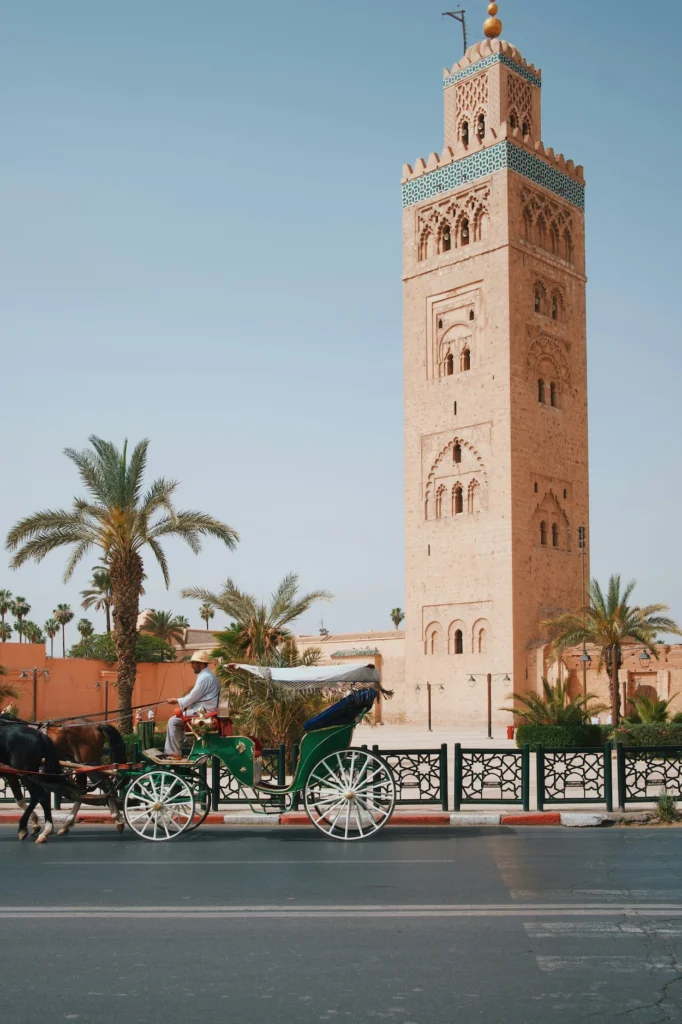 Horse-drawn carriage riding past the Koutoubia Mosque minaret in Marrakesh