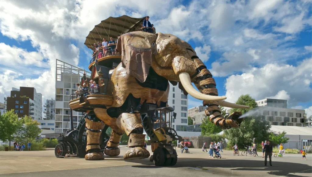 Grand Éléphant mechanical attraction walking through Parc des Chantiers plaza in Nantes, France