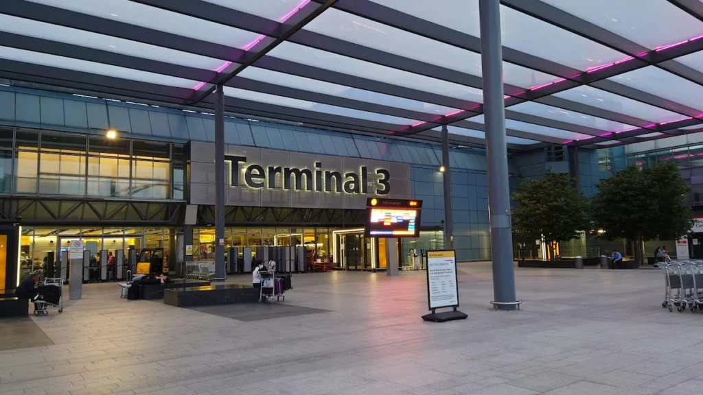 Heathrow Airport Terminal 3 exterior entrance under a massive canopy with glowing purple accents