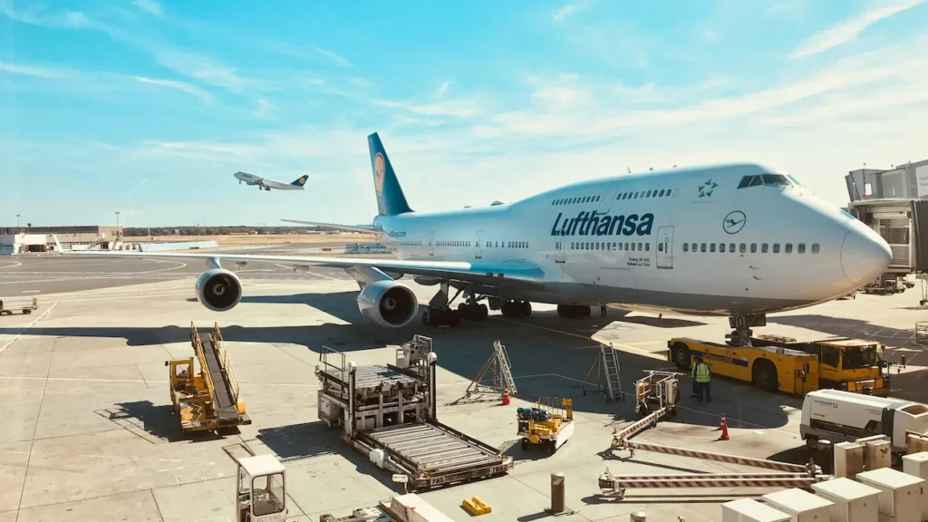 A Lufthansa Boeing 747-8 double-decker passenger airplane parked at an airport terminal gate