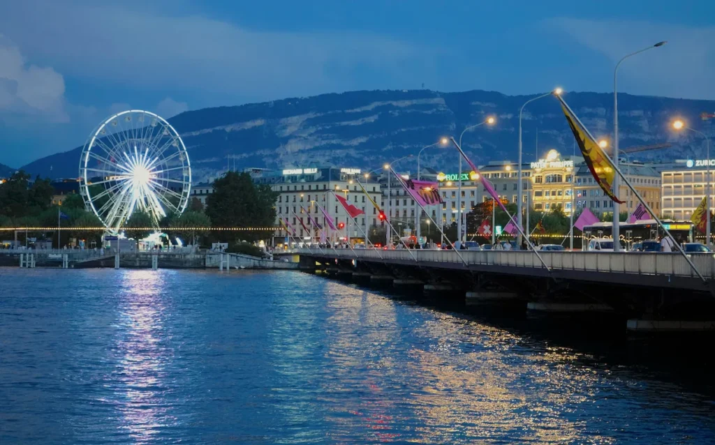 The illuminated Ferris wheel and Mont-Blanc Bridge over Lake Geneva in Switzerland