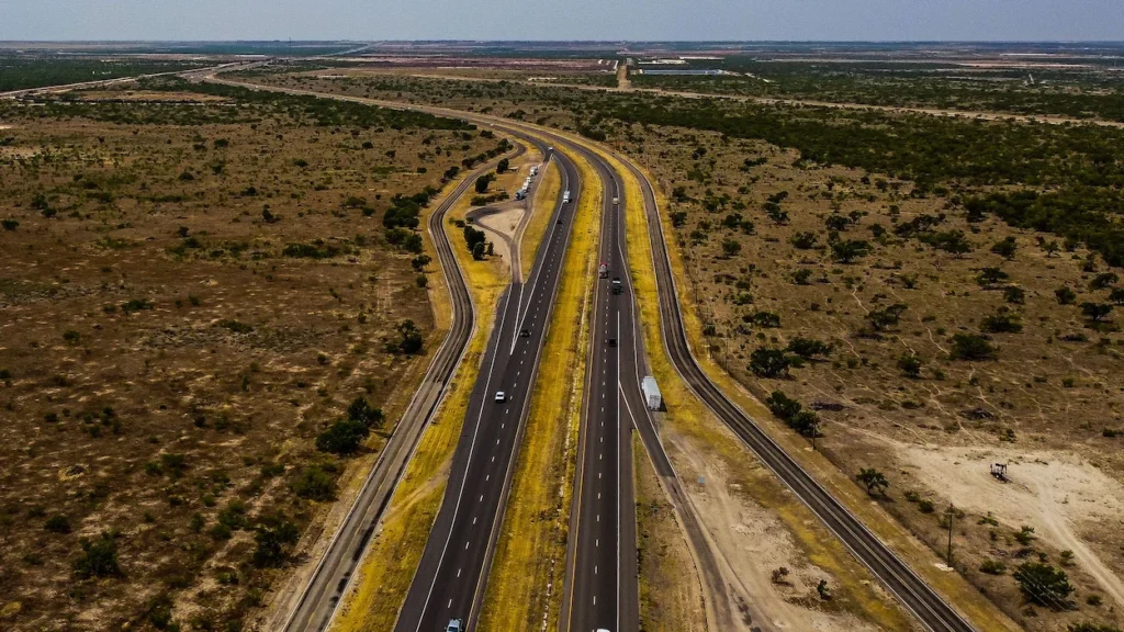 Aerial view of a multi-lane highway dividing through the arid landscape of Midland, Texas