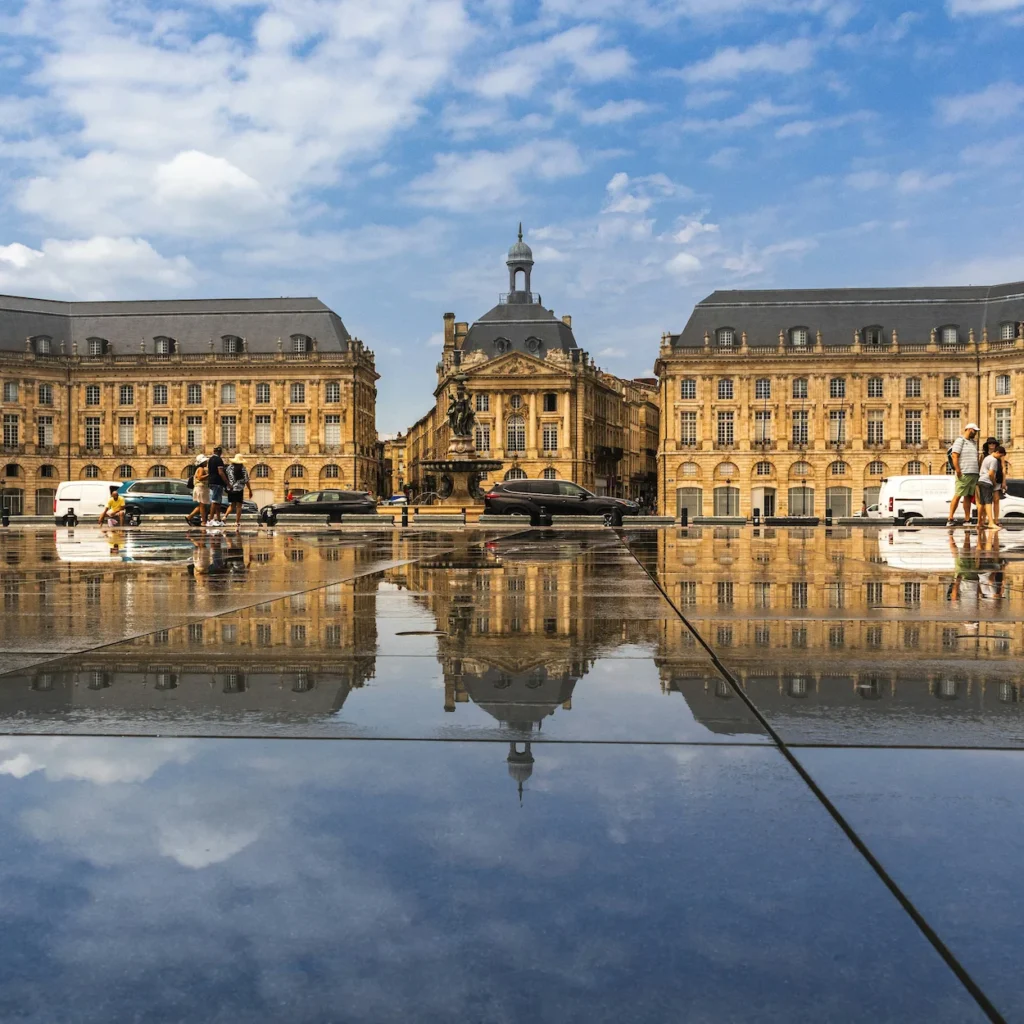 Place de la Bourse architecture mirrored perfectly on the wet surface of the Miroir d'eau pool in Bordeaux, France