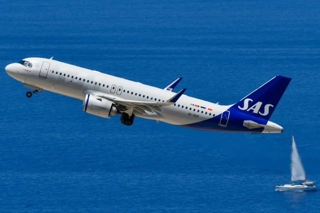 SAS Scandinavian Airlines Airbus A320neo registration SE-RUF taking off over blue water