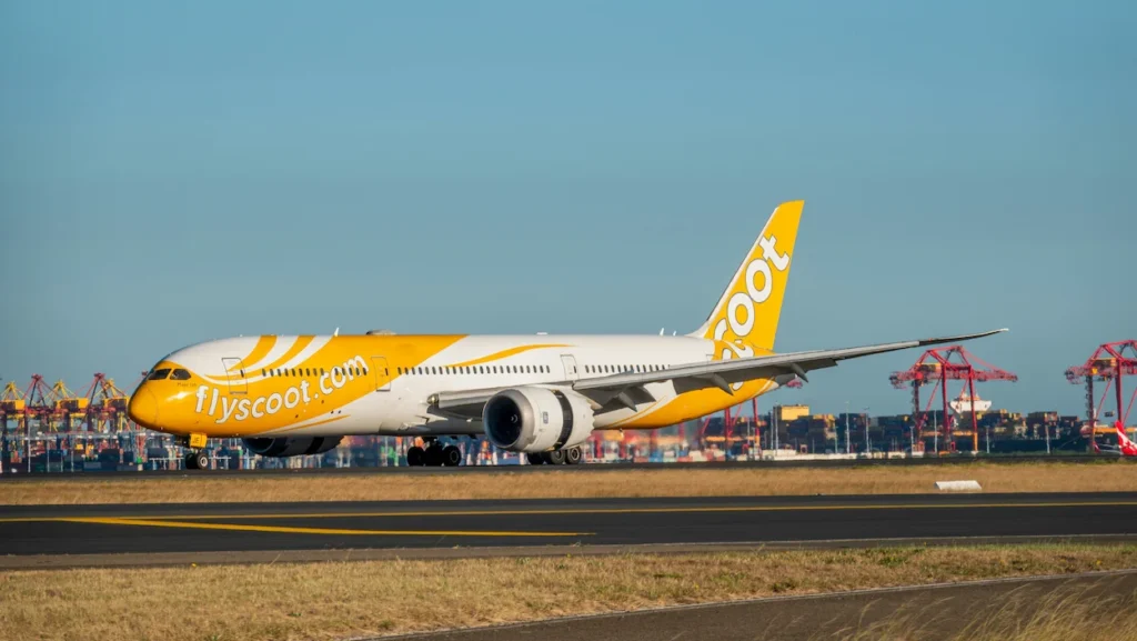 A Scoot Boeing 787 Dreamliner passenger airplane taxiing on an airport runway