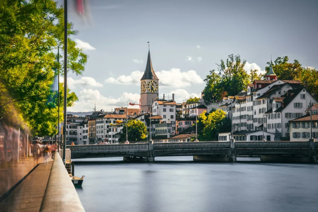 St. Peter Church clock tower rising above the Limmat River and buildings in Zurich, Switzerland