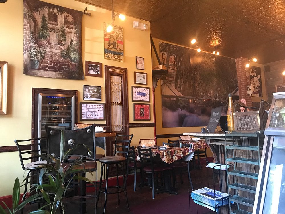 Cozy interior of TAPAteria with warm lighting, eclectic wall art, and rustic decor.