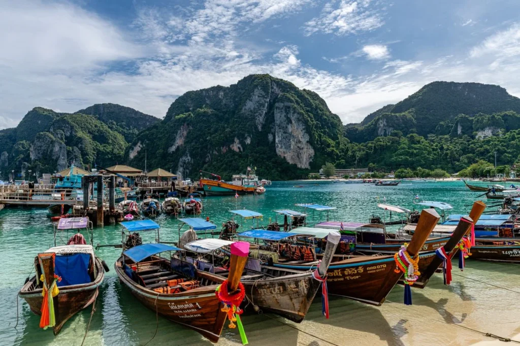 Wooden longtail boats parked in clear turquoise water at Tonsai Bay on Koh Phi Phi Don, Thailand