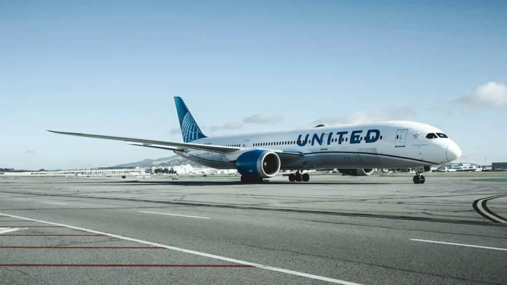 United Airlines Boeing 787 Dreamliner aircraft taxiing on a wide airport tarmac under a blue sky