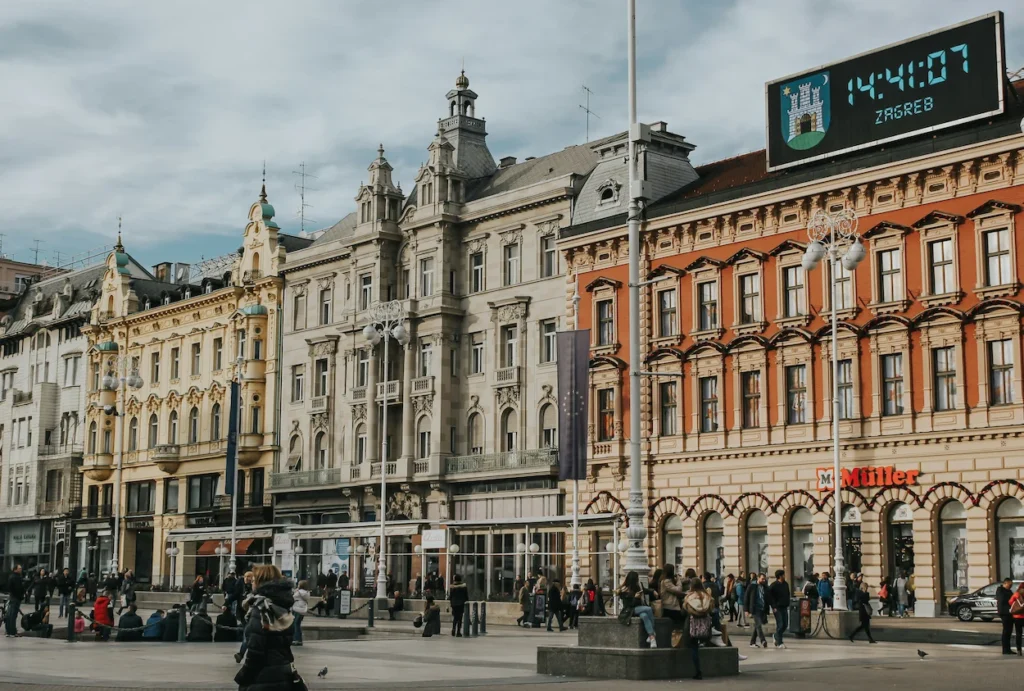 Historic Zagreb buildings at Ban Jelačić Square under a digital clock reading 14:41:07