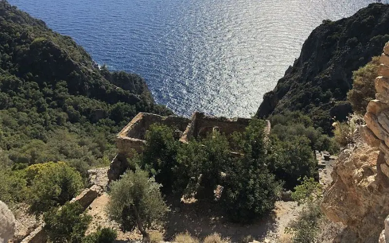 Cliffside ruins above the blue water at Afkule Monastery.