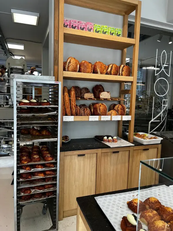 Shelves and trays filled with fresh bread and pastries at Bakkerij Wolf.