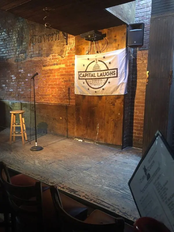 A small comedy stage with a Capital Laughs banner in Washington, DC.