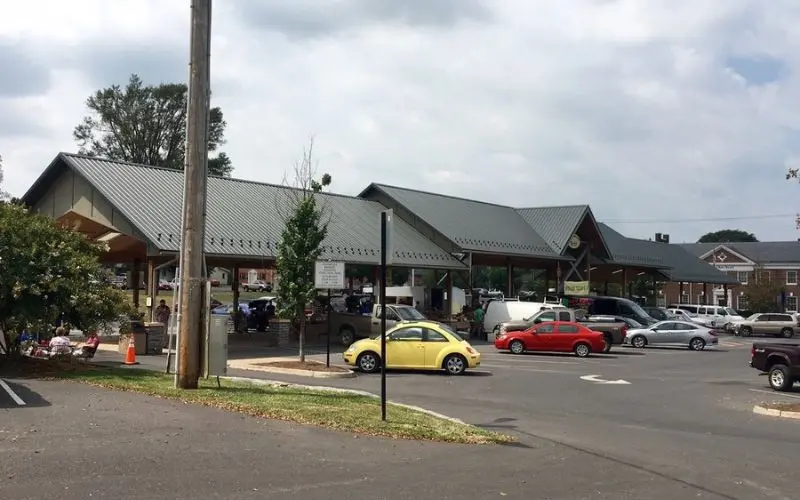 Covered stalls and shoppers at the Harrisonburg Farmers Market.
