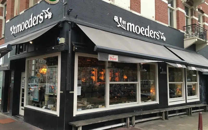 Exterior of Moeders restaurant with large windows and black signage.