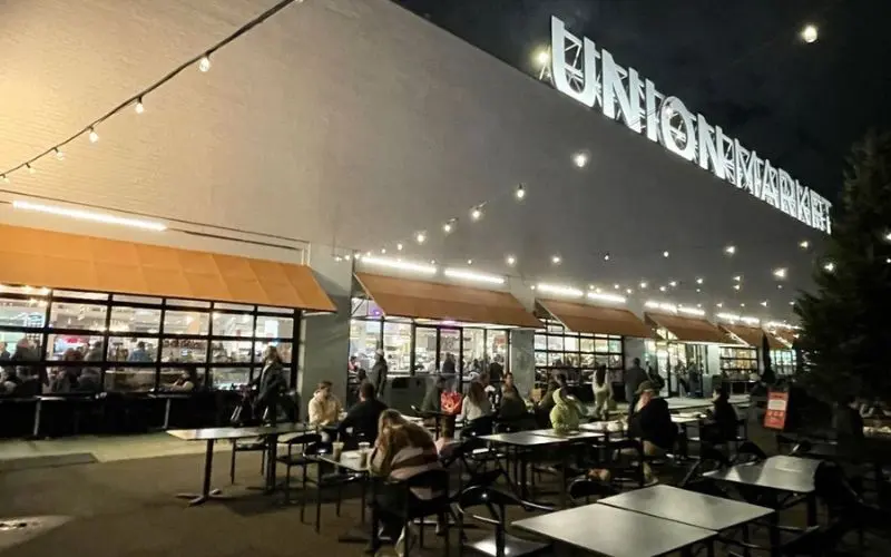 People sit outside under string lights at Union Market in Washington, DC.