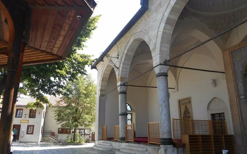 Exterior courtyard of Ali Pasha Mosque, featuring arched colonnades and a peaceful open space.