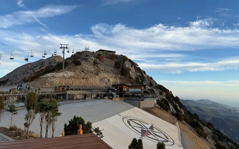 Mountain summit with cable cars and a compass design at Babadağ Mountain.