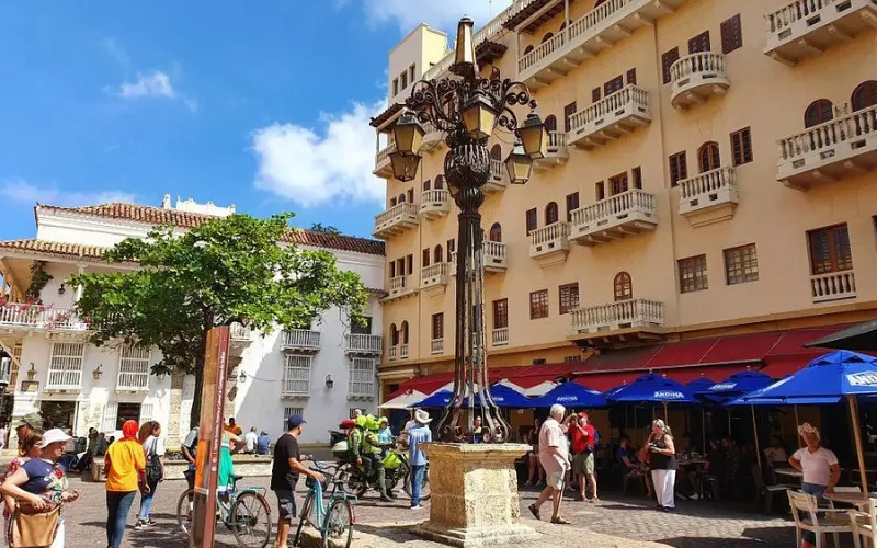 People and cafes around Plaza Santo Domingo with colonial buildings.