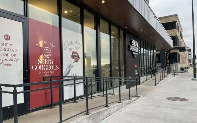 The entrance of Sorry Gorgeous cocktail bar shows bold red and white signage.