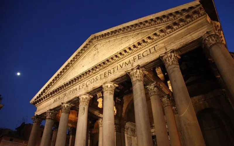 Pantheon in Rome, Italy with grand columns and moonlit sky.