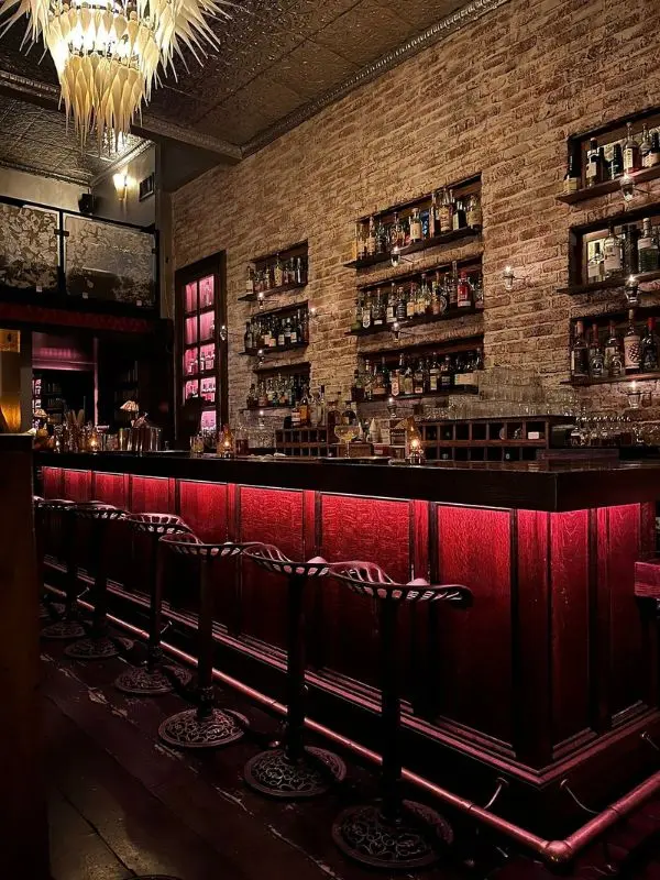Dimly lit bar with shelves of liquor at Bourbon & Branch.